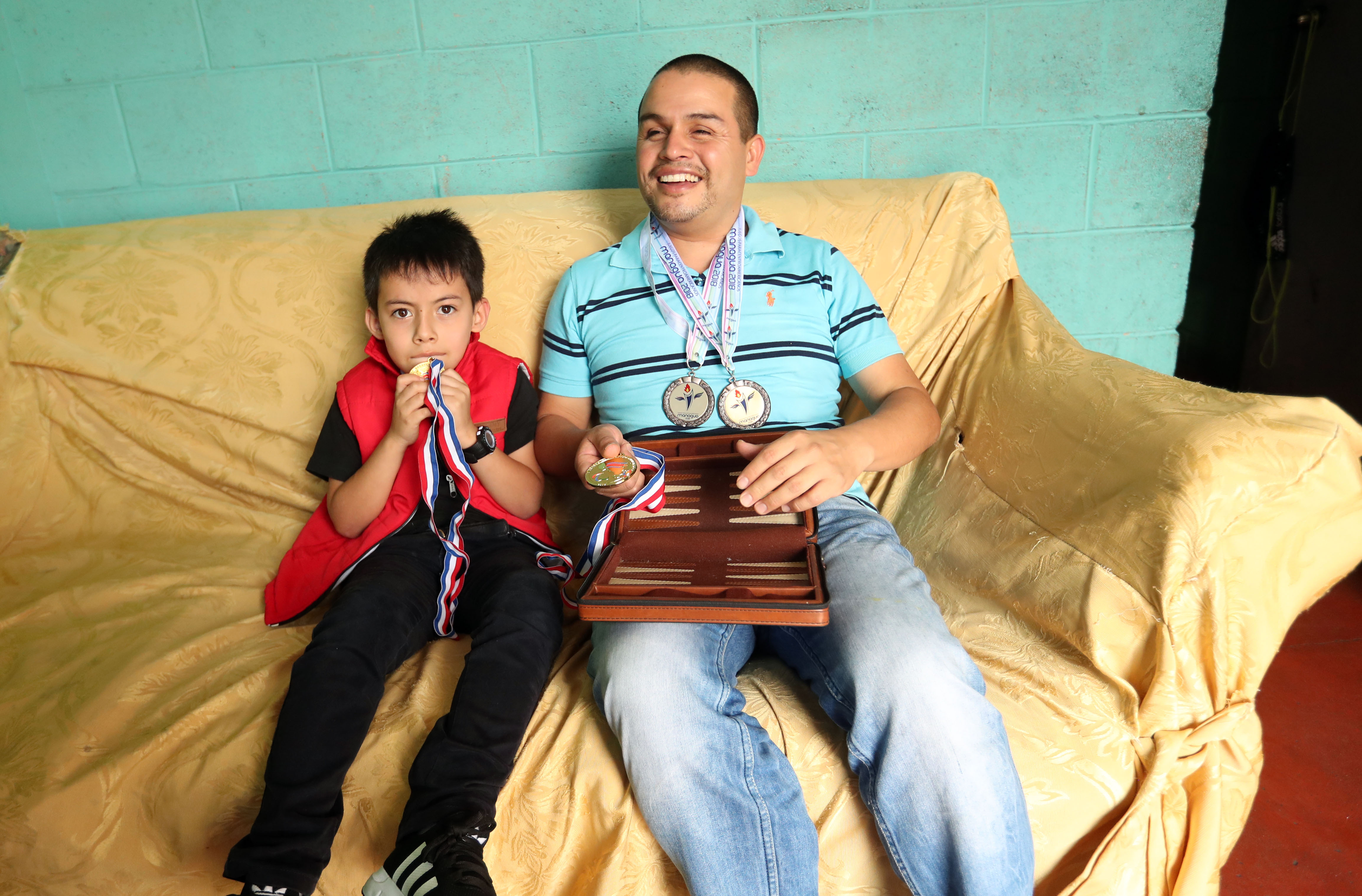Brayan, junto a su hijo Matías, recordando sus triunfos en el deporte. (Foto Prensa Libre: Jeniffer Gómez)