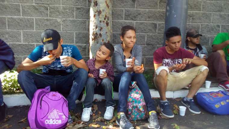 Migrantes hondureños descansan en el Anillo Periférico para desayunar. (Foto Prensa Libre: Edwin Pitán).