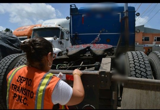 Autoridades de Tránsito colocan reflectivos en camiones para evitar accidentes durante la noche y la lluvia