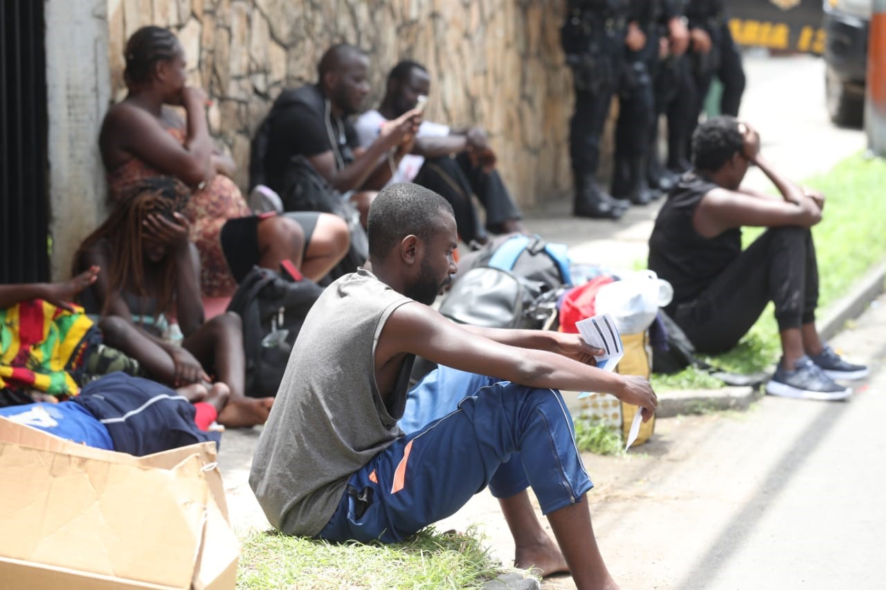 Inmigrantes descansan en la vía pública frente al albergue de Migración, en zona 5, custodiados de policías. (Foto Prensa Libre: Esbin García) 