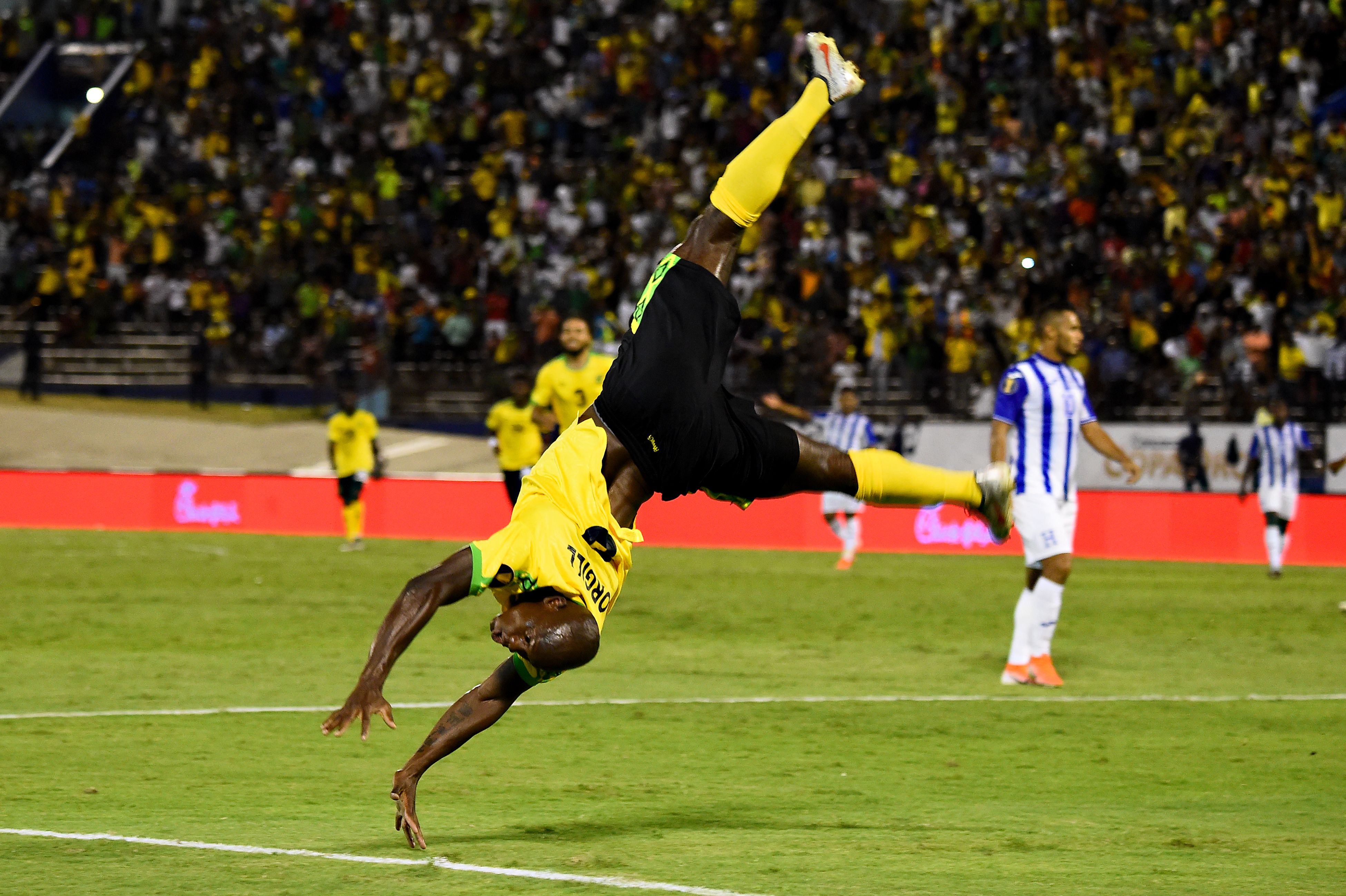 El ariete jamaiquino Dever Orgill celebra de forma acrobática el segundo gol que le marcó a los hondureños (Foto Prensa Libre: AFP)
