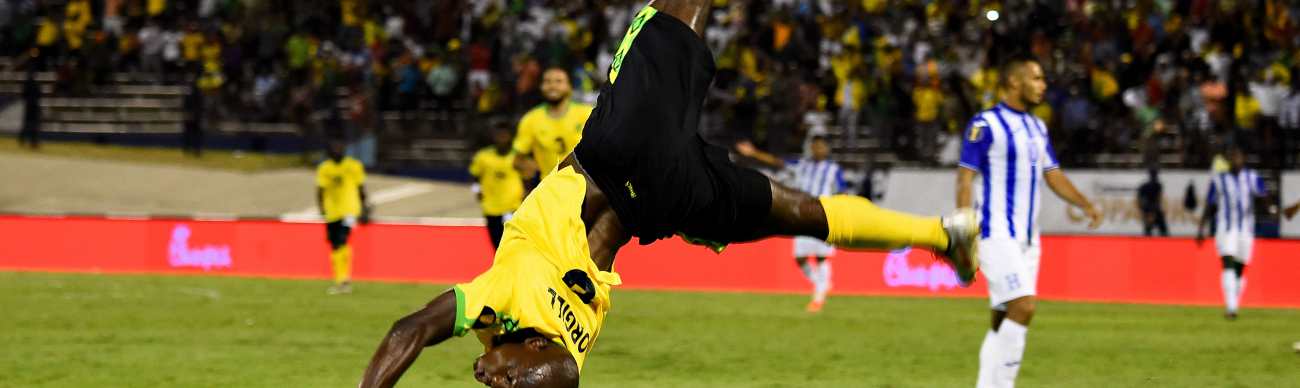 El ariete jamaiquino Dever Orgill celebra de forma acrobática el segundo gol que le marcó a los hondureños (Foto Prensa Libre: AFP)