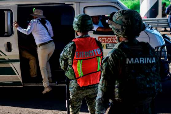 Un agente de inmigración mexicano verifica los documentos en un punto de control en las afueras de Tapachula, estado de Chiapas, México. Foto Prensa Libre: AFP
