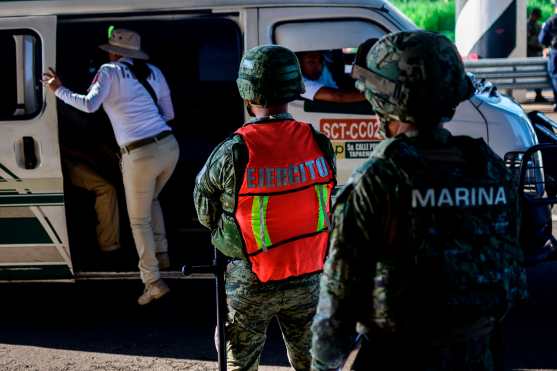 Un agente de inmigración mexicano verifica los documentos en un punto de control en las afueras de Tapachula, estado de Chiapas, México. Foto Prensa Libre: AFP 