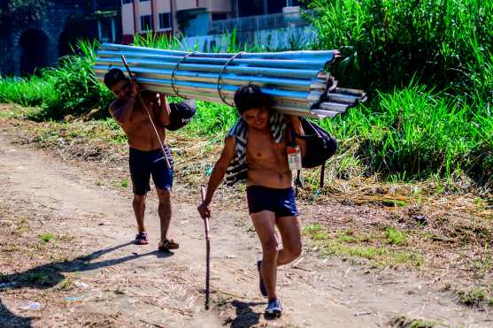 Algunas personas traen de Guatemala materiales de construcción hacia México. Foto Prensa Libre: AFP