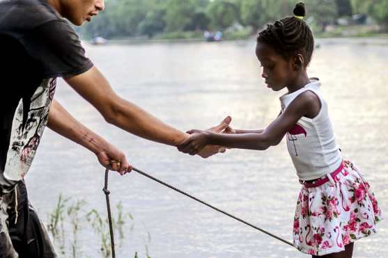 Se ayuda a una niña a bajar de una balsa improvisada después de cruzar ilegalmente el río Suchiate. Foto Prensa Libre: AFP