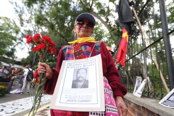 Las personas mostraron varias fotografías de las personas que desaparecieron durante la época del enfrentamiento. Foto Prensa Libre: Óscar Rivas
