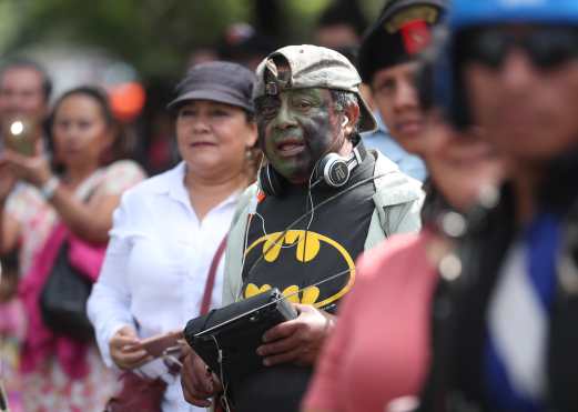 Con el rostro pintado, personas esperan el paso del desfile en la Avenida Reforma. Foto Prensa Libre: Esbin García