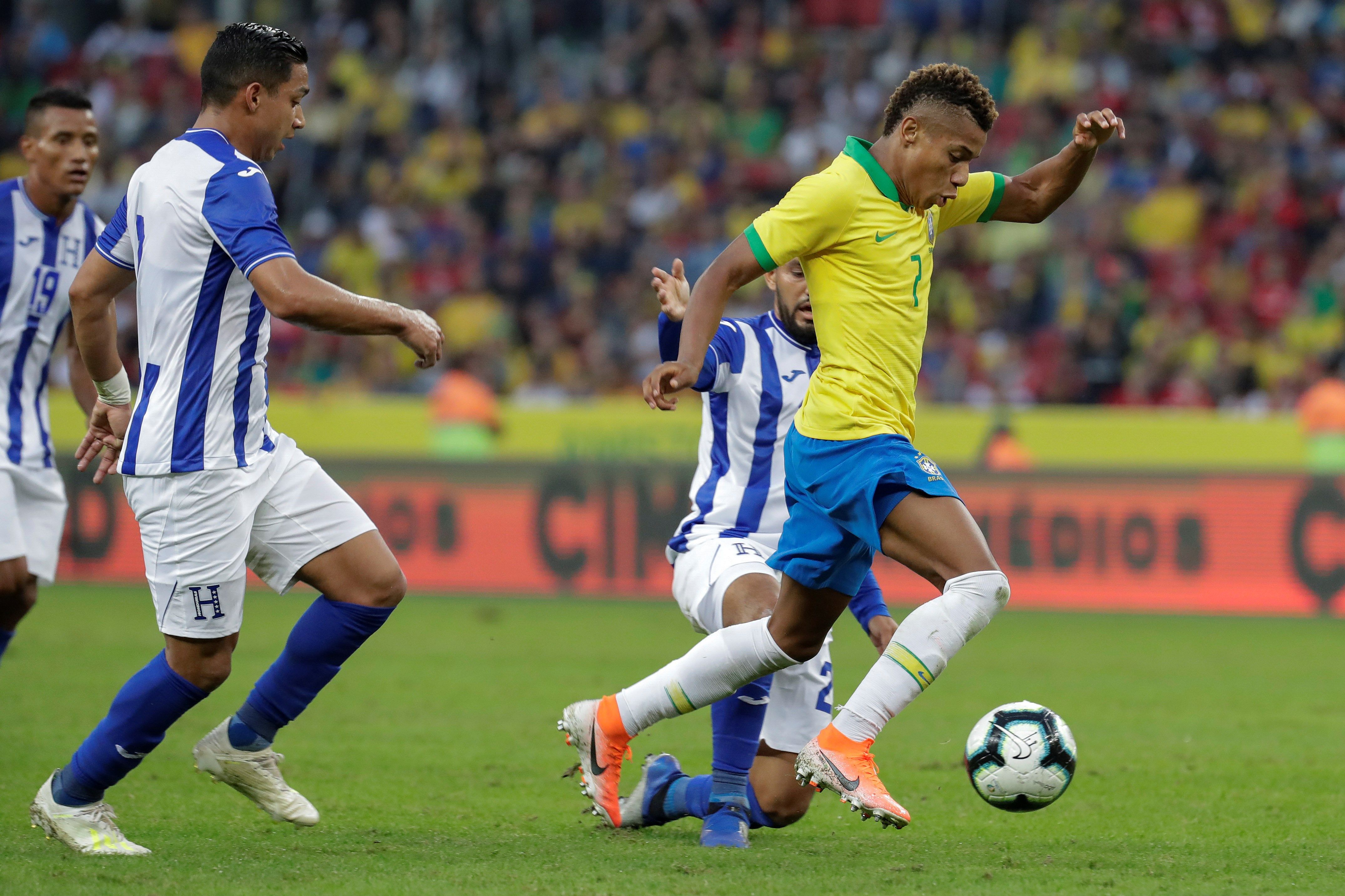 El jugador David Neres (derecha) de Brasil disputa el balón con Jorge Alvarez (i) de Honduras. El atacante es una de las nuevas figuras para Tite. (Foto Prensa Libre: EFE)