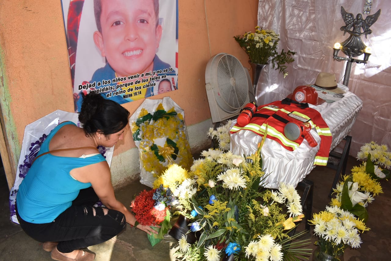 Wendy González coloca flores a un costado del ataúd de su hijo. (Foto Prensa Libre: Mario Morales). 

