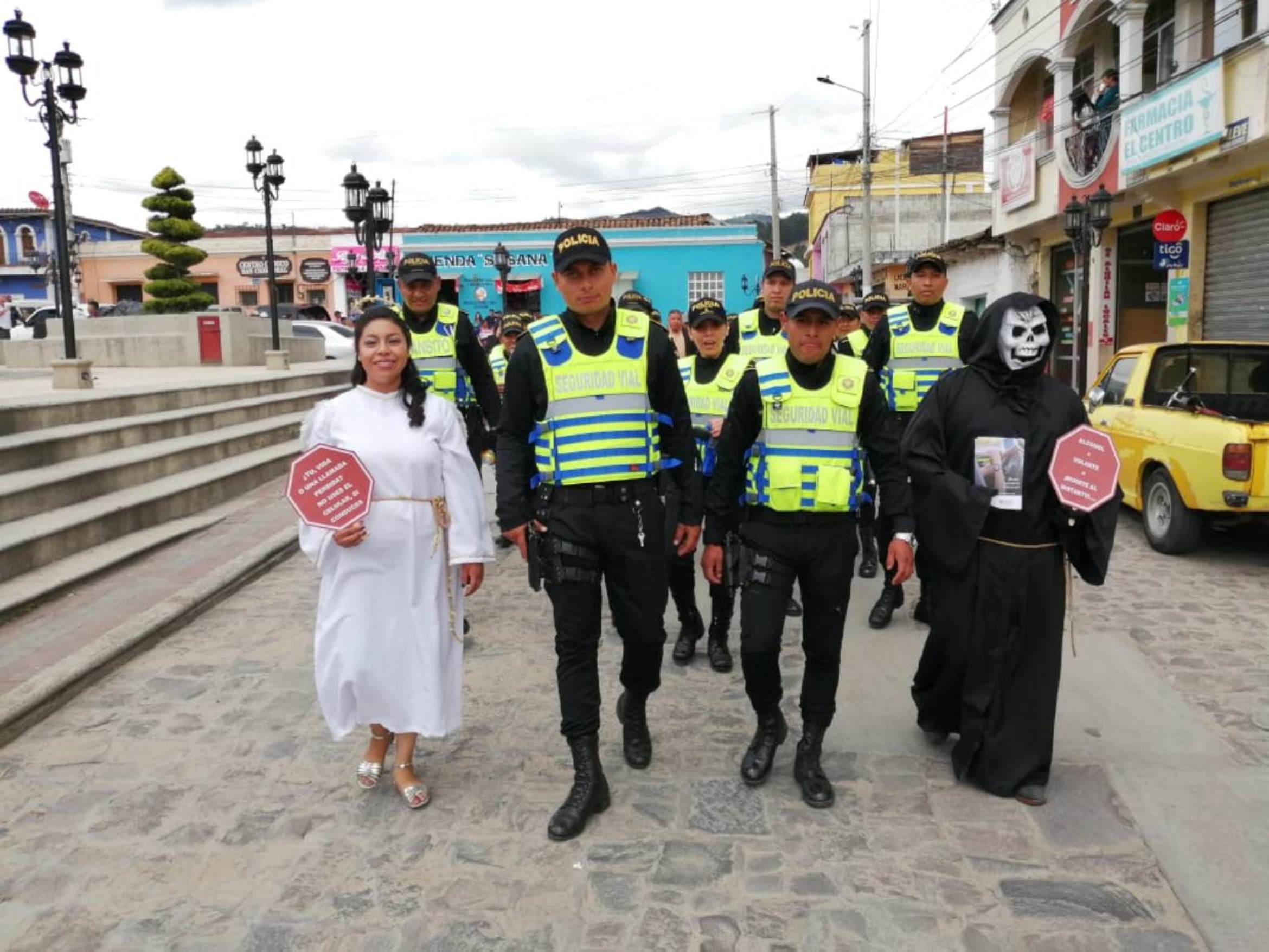 Policías caminaron hasta la nueva sede, los acompañaron dos personas disfrazadas que invitaban a la población a no usar el celular al conducir. (Foto Prensa Libre: María Longo) 