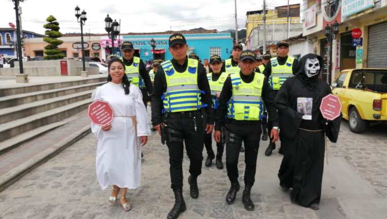 Policías caminaron hasta la nueva sede, los acompañaron dos personas disfrazadas que invitaban a la población a no usar el celular al conducir. (Foto Prensa Libre: María Longo) 