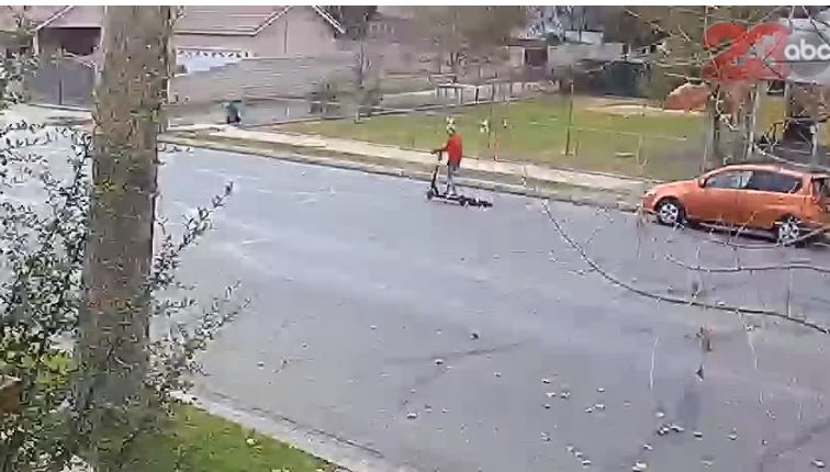 Captura de video, publicado por 23 ABC, donde se observa al perrito atado atrás de la patineta eléctrica de la mujer. 
