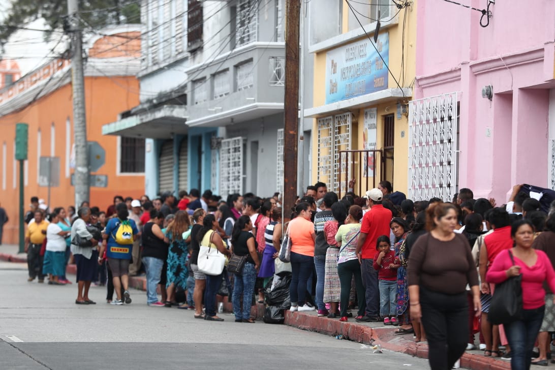 Personas hacen fila para recibir víveres en establecimiento educativo de la zona 1. (Foto Prensa Libre: Carlos Hernández). 