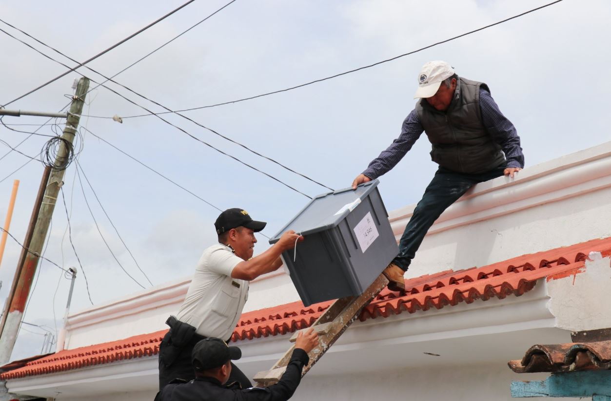 Autoridades recuperan cajas electorales en el techo de la sede de la Junta Electoral Municipal de San Antonio Ilotenango. (Foto Prensa Libre: Héctor Cordero)