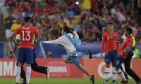 Chile's Gonzalo Jara (R) tries to knock an invader down during the Copa America football tournament group match against Uruguay at Maracana Stadium in Rio de Janeiro, Brazil, on June 24, 2019. (Photo by Carl DE SOUZA / AFP)