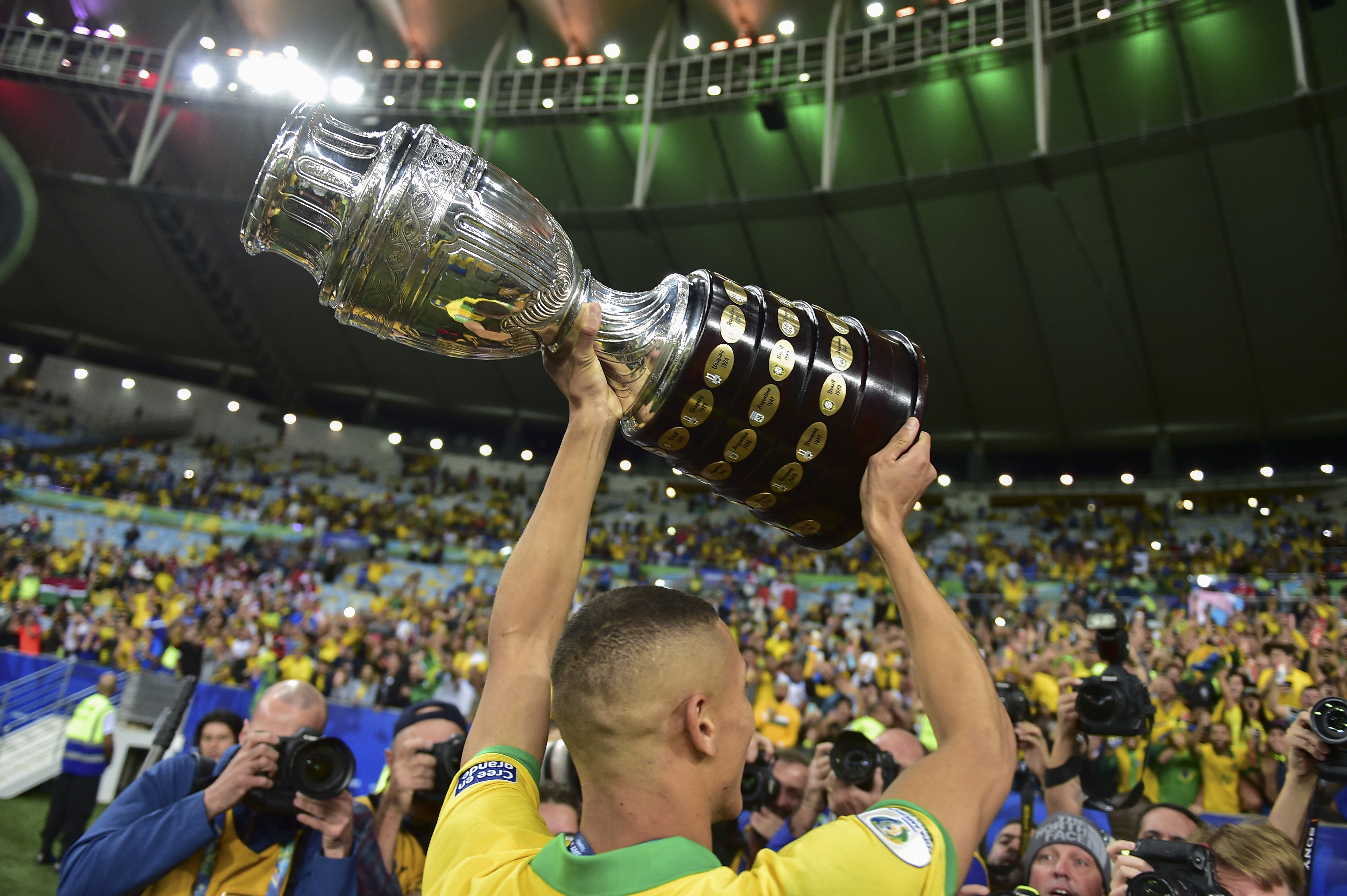 Richarlison, anotador del tercer gol de Brasil en la final contra Perú alza el trofeo de campeones de la Copa América 2019. (Foto Prensa Libre: AFP) 