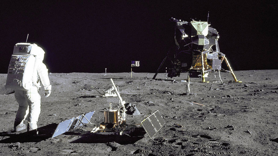 Aldrin despliega el experimento sísmico en la superficie lunar. Un poco más atrás se ve el experimento del retroreflector y, al fondo, el módulo de alunizaje Águila. (Foto Prensa Libre: NASA)