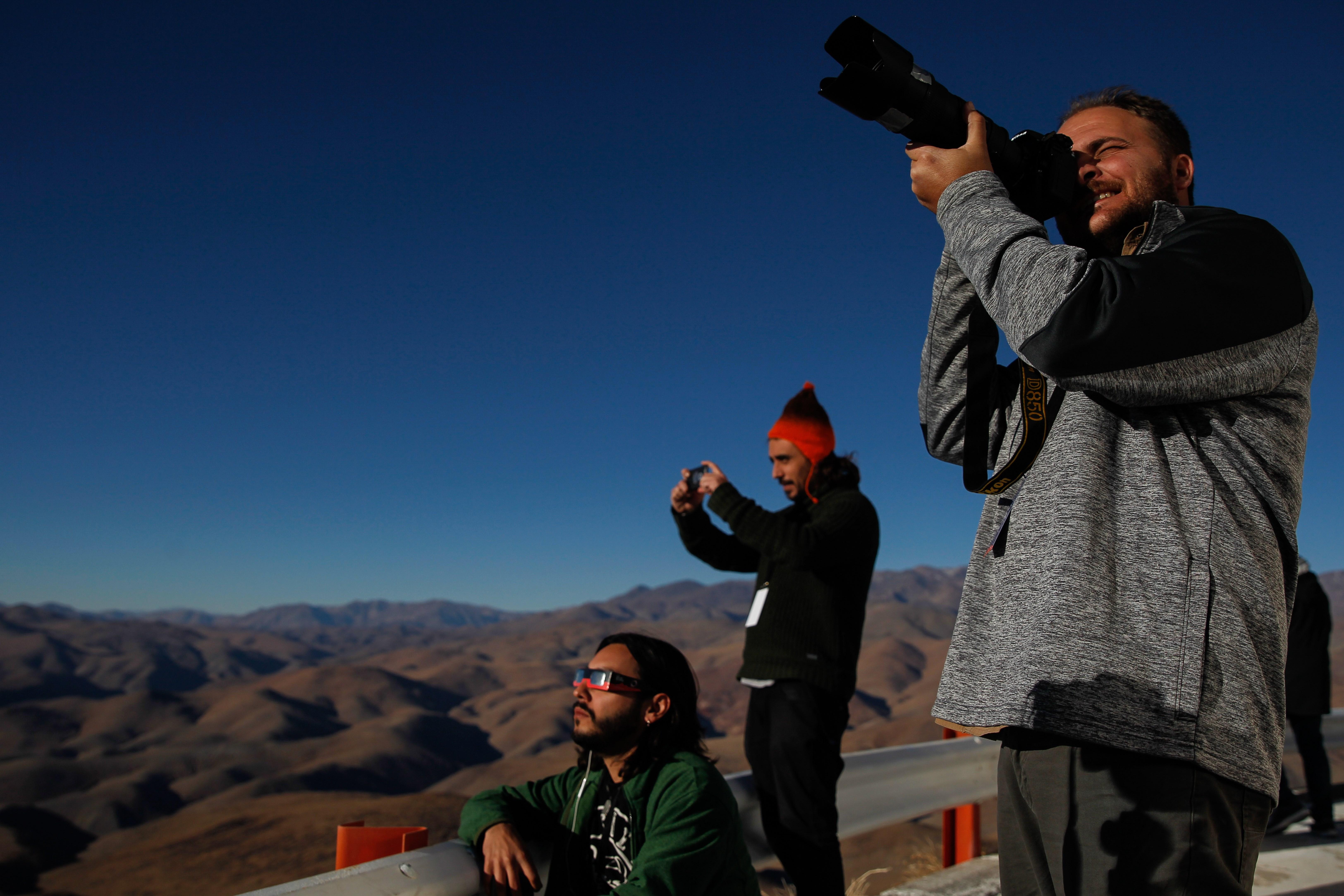 Sergio Izquierdo, en primer plano, durante el eclipse solar en el observatorio de La Silla, en Chile. (Foto Prensa Libre: EFE)
