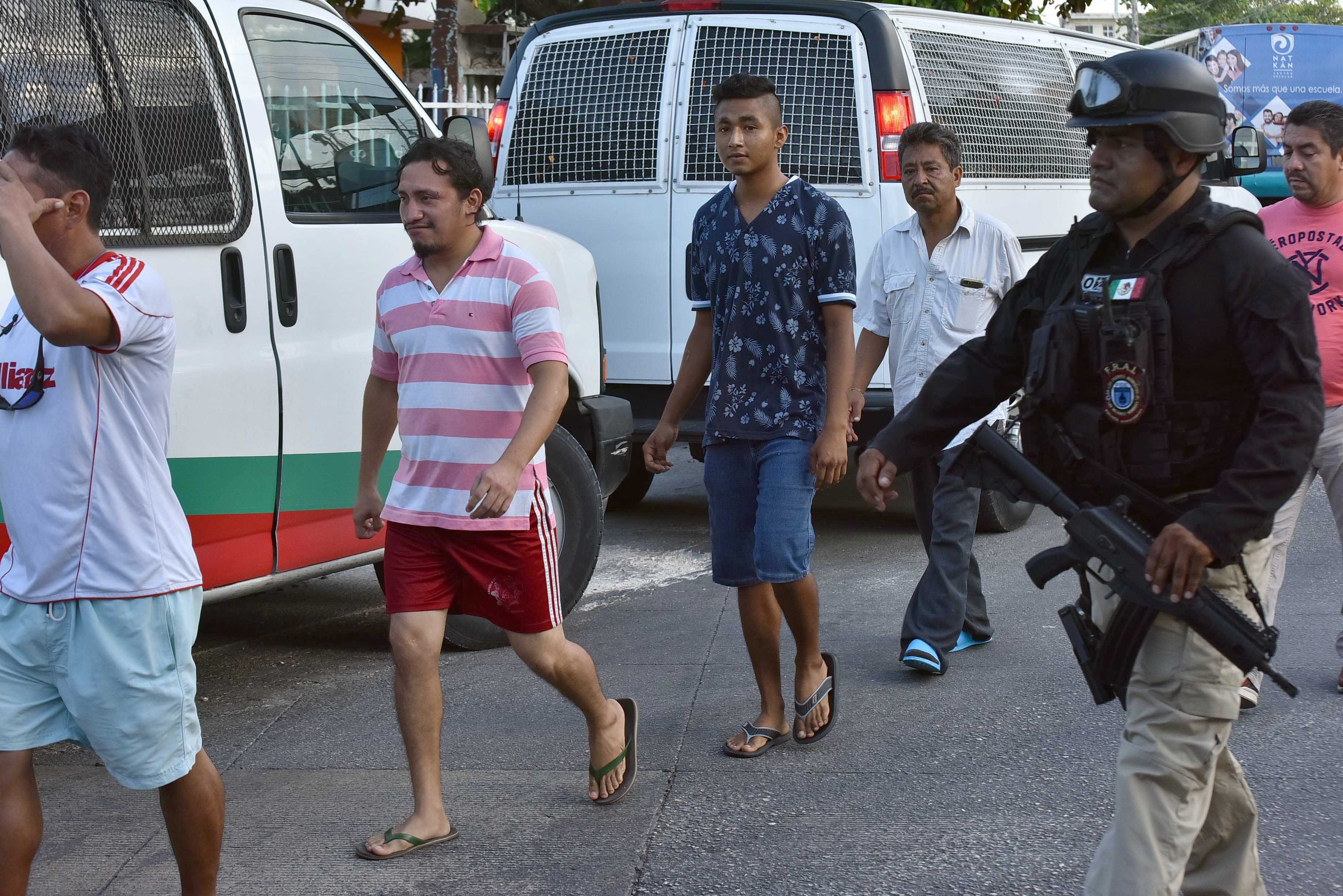 Agentes de la Policía Ministerial, apoyados por la Guardia Nacional, aseguran a 54 migrantes de nacionalidad centroamericana, este martes en la ciudad de Cancún, Quintana Roo . (Foto Prensa Libre: EFE)