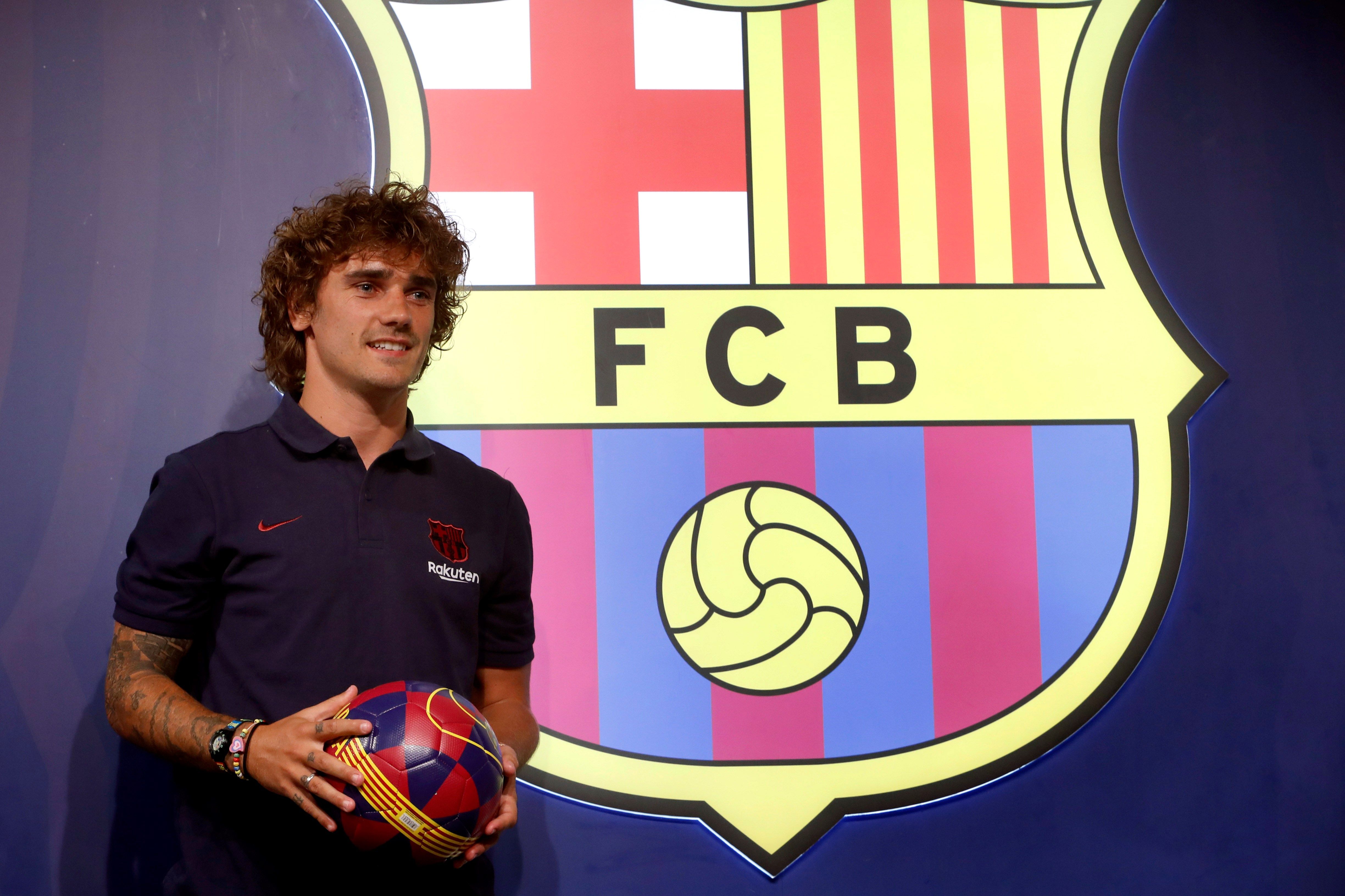 El delantero francés Antoine Griezmann, nuevo fichaje del Barcelona, posa durante una sesión fotográfica en la tienda del club en el Camp Nou. (Foto Prensa Libre: EFE)