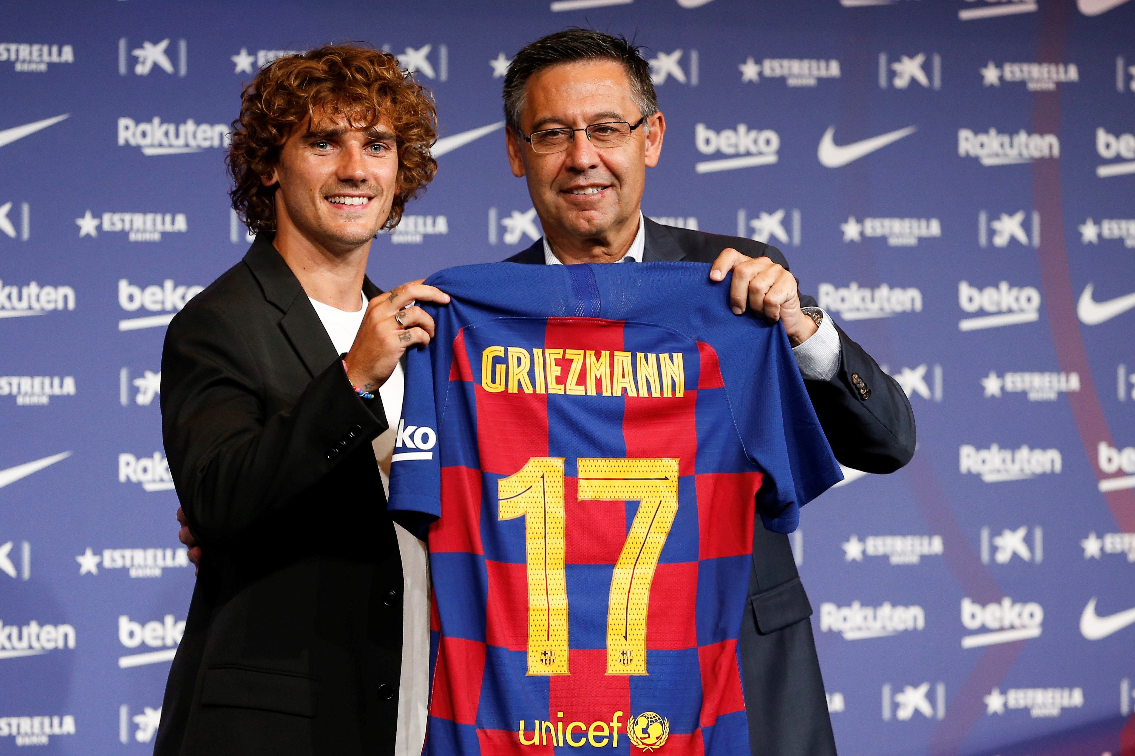 El delantero francés Antoine Griezmann (i) posa para los medios de comunicación con el presidente del club, Josep Maria Bartomeu en el Camp Nou tras firmar como jugador del F.C. Barcelona. (Foto Prensa Libre: EFE)