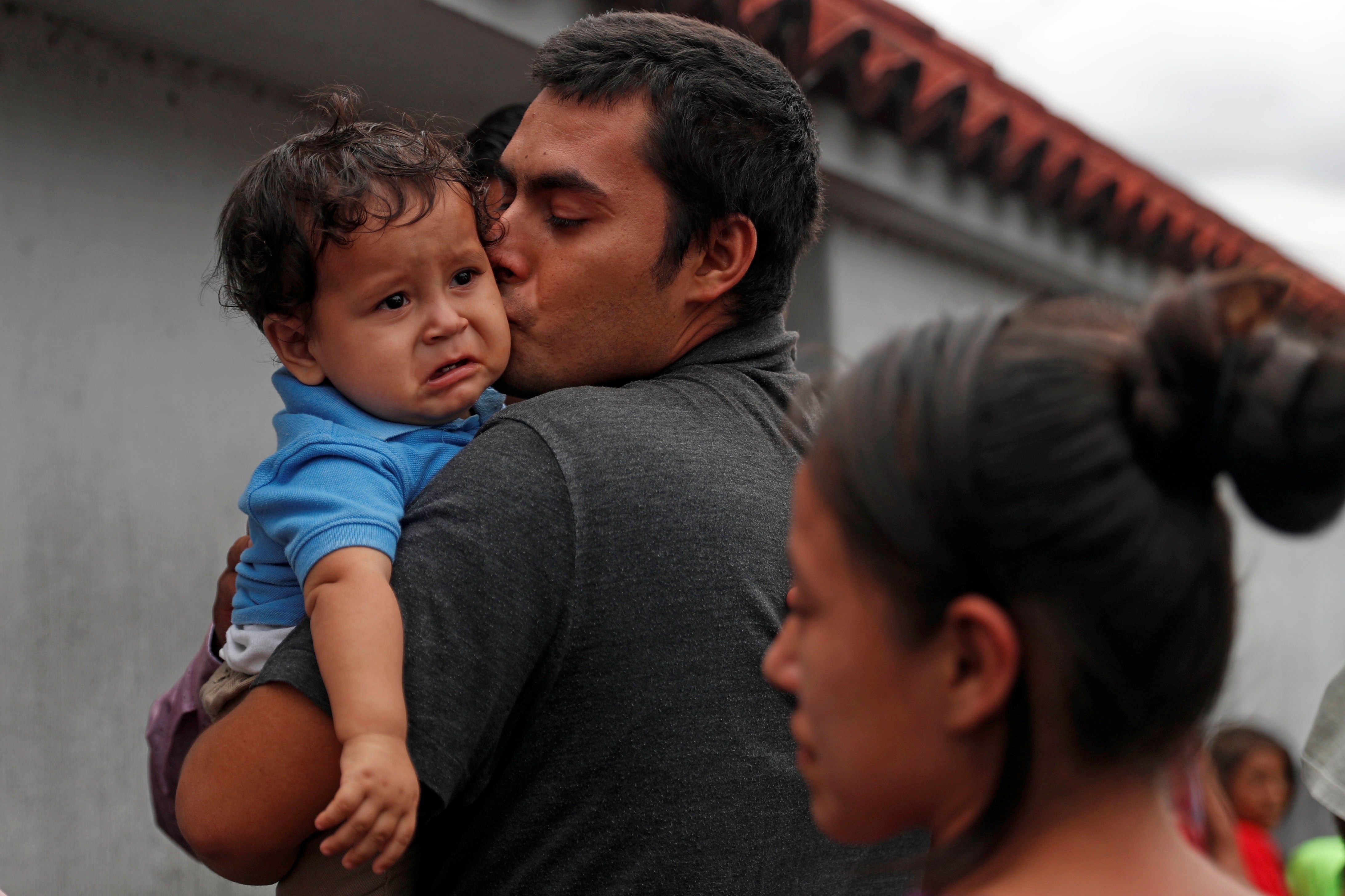 Kevin, migrante guatemalteco recién deportado de Estados Unidos, besa a su hijo Osaías, de 1 año, después de permanecer fuera del país por dos meses, tras su llegada junto a un grupo de migrantes también deportados a Guatemala. (Foto Prensa Libre: EFE)