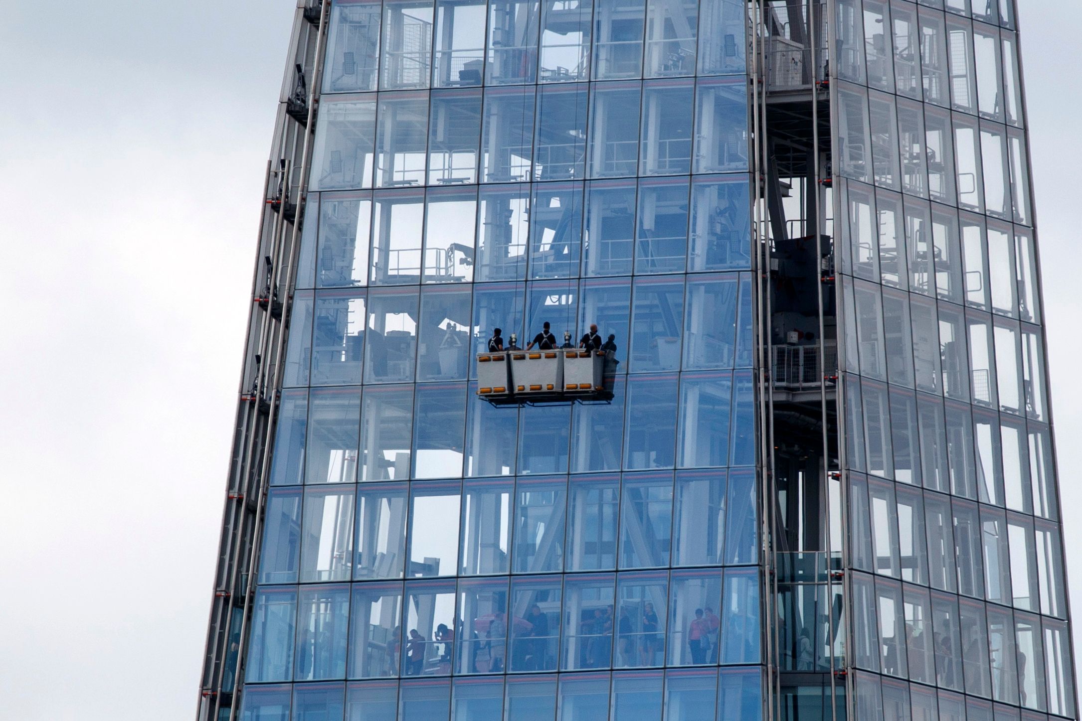 Varias personas limpian las ventanas  del rascacielos The Shard, el más grande de Europa. (Foto Prensa Libre: AFP)