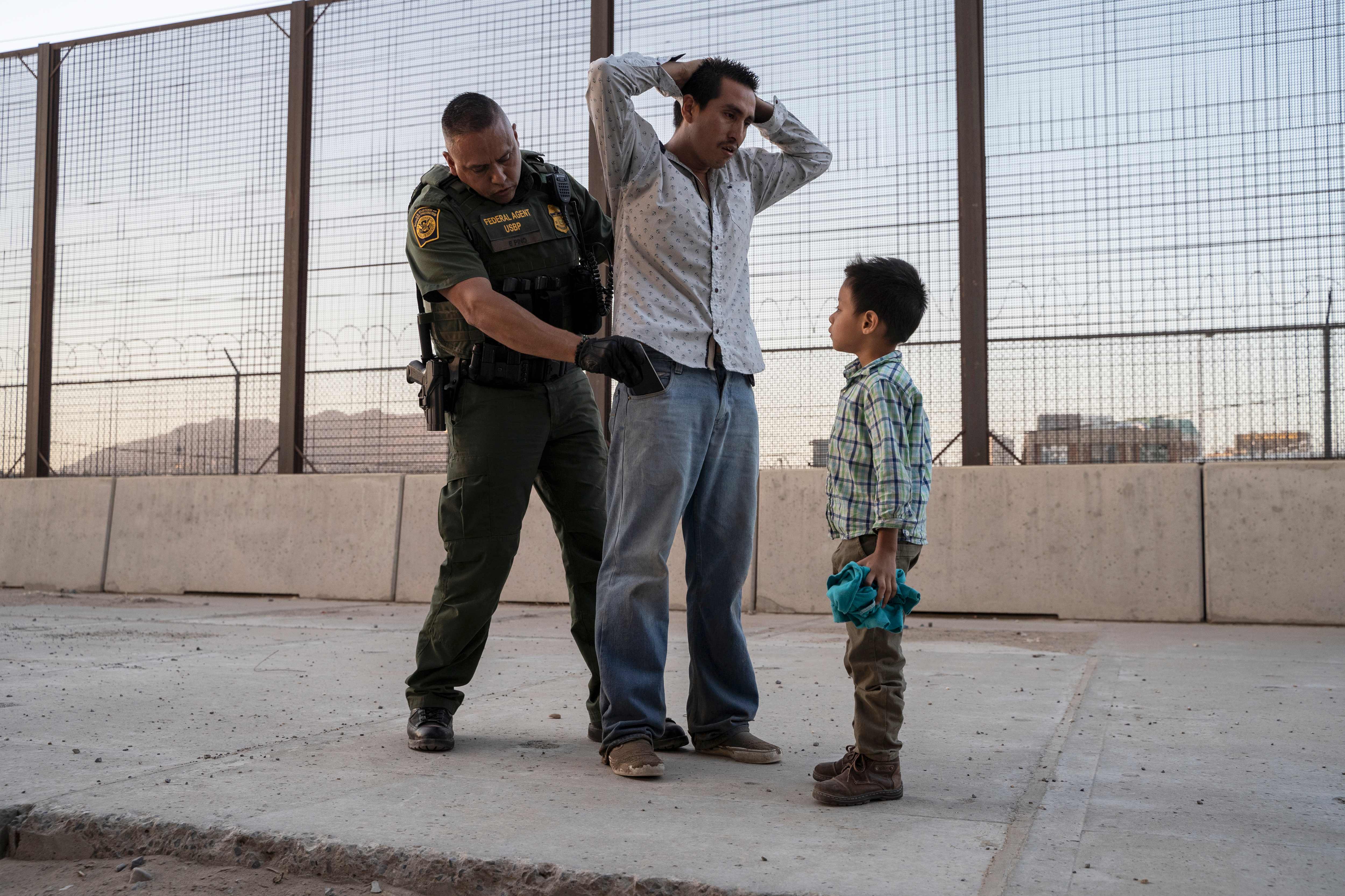 Un padre con su hijo son revisados por un guardia de la Patrulla Fronteriza. (Foto Prensa Libre: AFP)