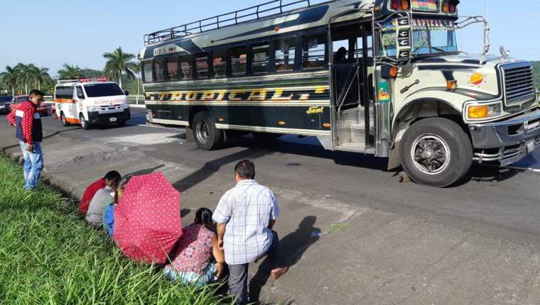 Usuarios permanecen junto a bus que fue objeto de asalto en la Autopista Palín-Escuintla. (Foto Prensa Libre: Enrique Paredes).