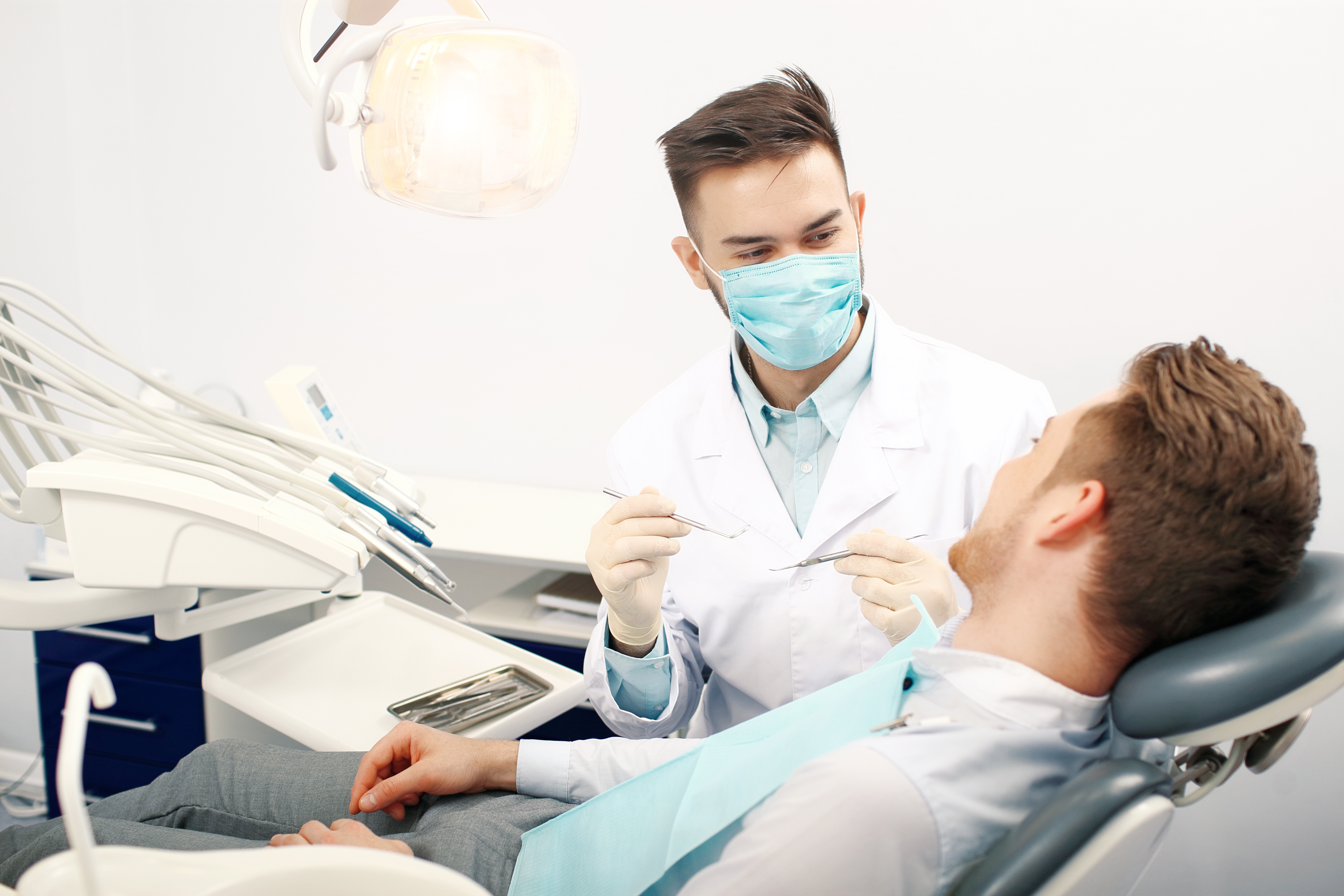 Врач который ставит зубы. Стоматолог. Стоматолог и пациент. Пациент в стоматологическом кресле. Стоматолог мужчина.