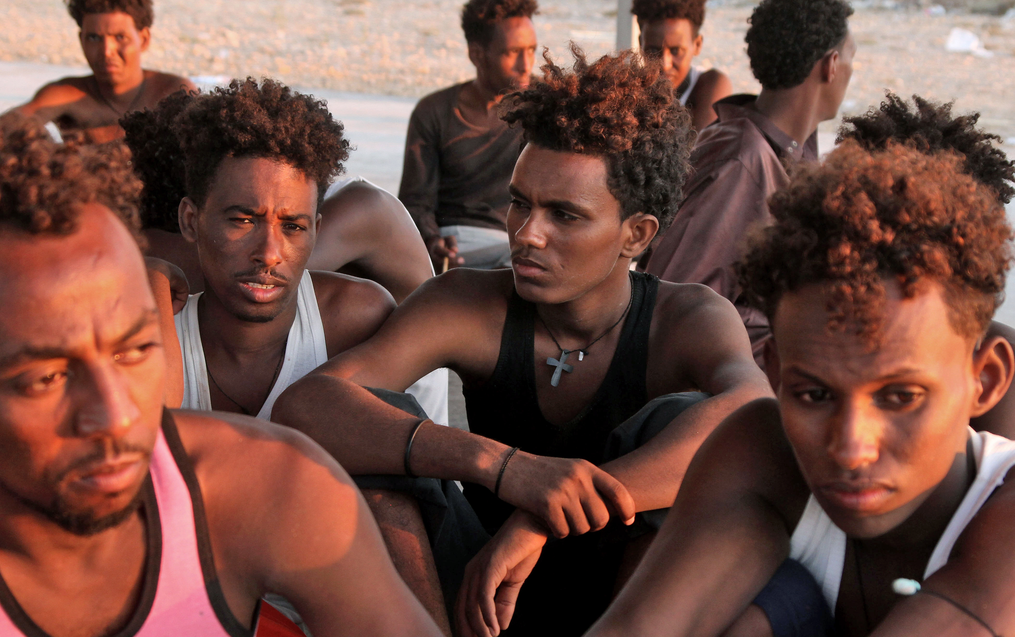 Los migrantes rescatados se sientan en la costa de Khoms, a unos 100 kilómetros  de la capital de Libia. (Foto Prensa Libre: AFP)