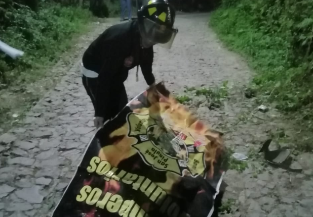 Bombero cubre el cadáver del motorista que murió en San José Pinula. (Foto Prensa Libre: @BVoluntariosGT).