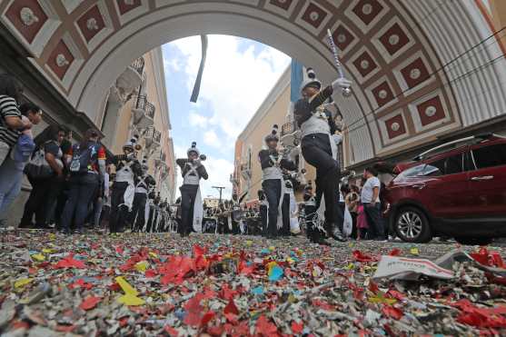 El papel de los cohetes quemados sirve de alfombra para el paso de las bandas.