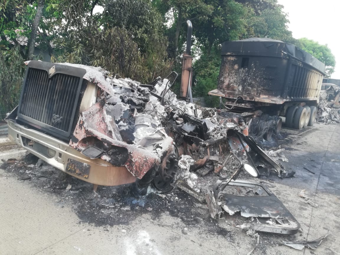 Uno de los tráileres que fue quemado por una turba en la salida de El Estor, Izabal. (Foto Prensa Libre: Dony Stewart).