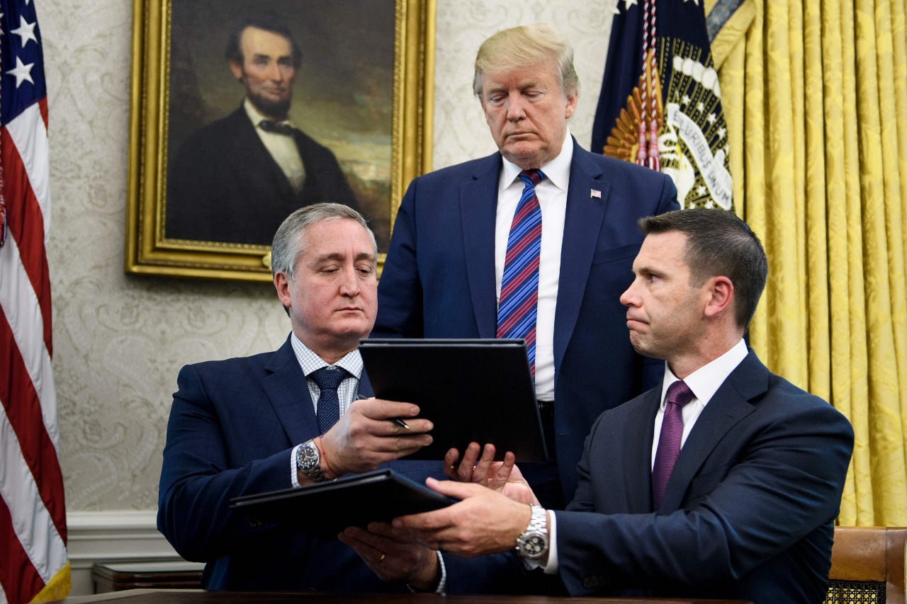 Donald Trump observa el acuerdo firmado entre Enrique Degenhart y Kevin McAleenan. (Foto Prensa Libre: AFP)