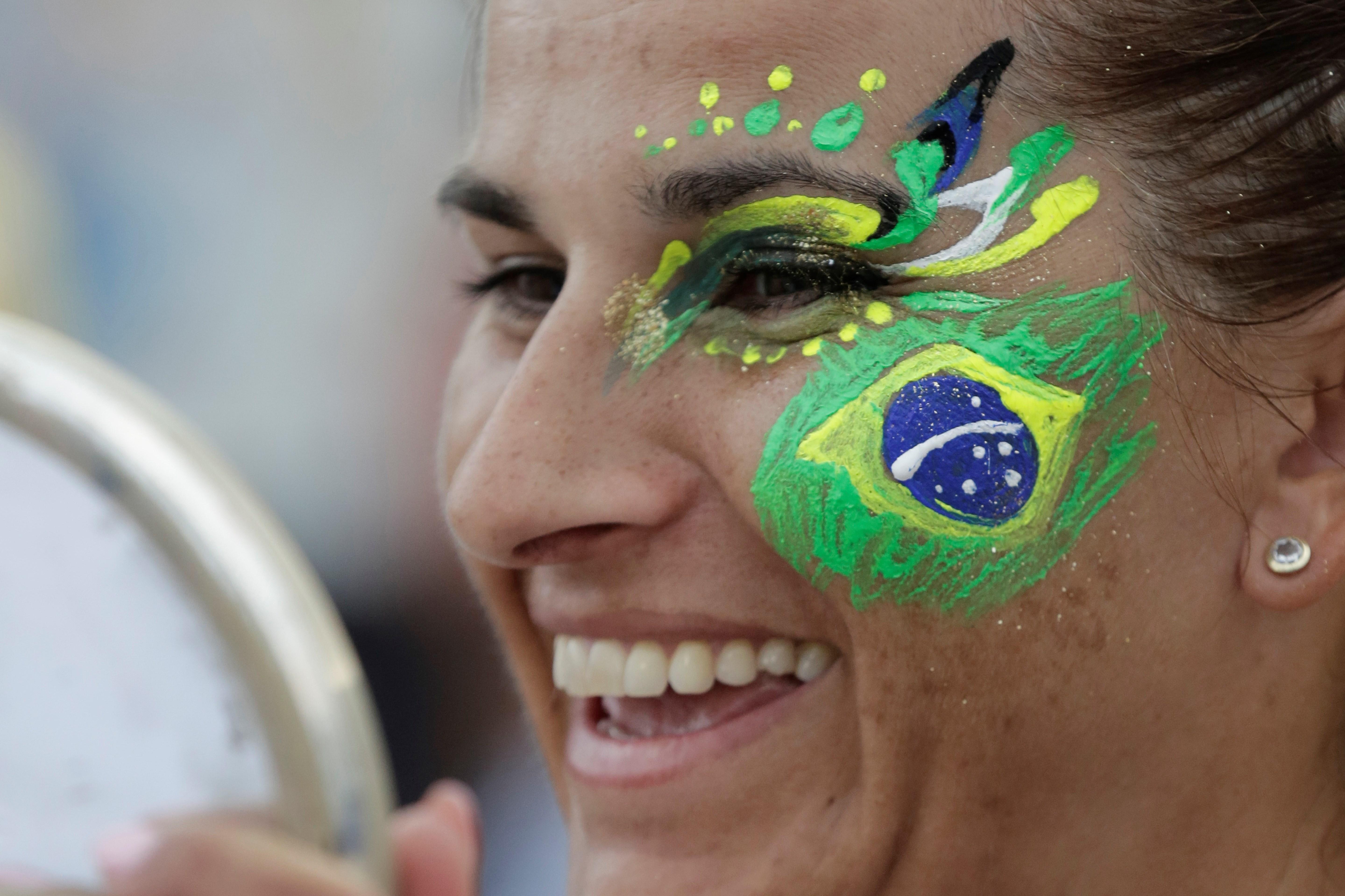 Una aficionada ríe tras recibir un maquillaje del artista colombiano Guillermo León Londoño este martes en el espacio Evolución es Conmebol en la playa de Copacabana en Río de Janeiro, Brasil (Foto Prensa Libre: EFE)