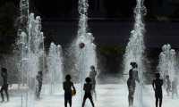 (FILES) In this file photo taken on July 26, 2018 Children are playing with water jets at the Parc Andre Citroen in Paris. - Up to 40 degrees celsius during the day, 25 at night: France will know next week a heat wave exceptional in its precocity and intensity, warns on June 21, 2019 Meteo-France, saying that the heat waves are multiplying with the global warming. (Photo by ALAIN JOCARD / AFP)