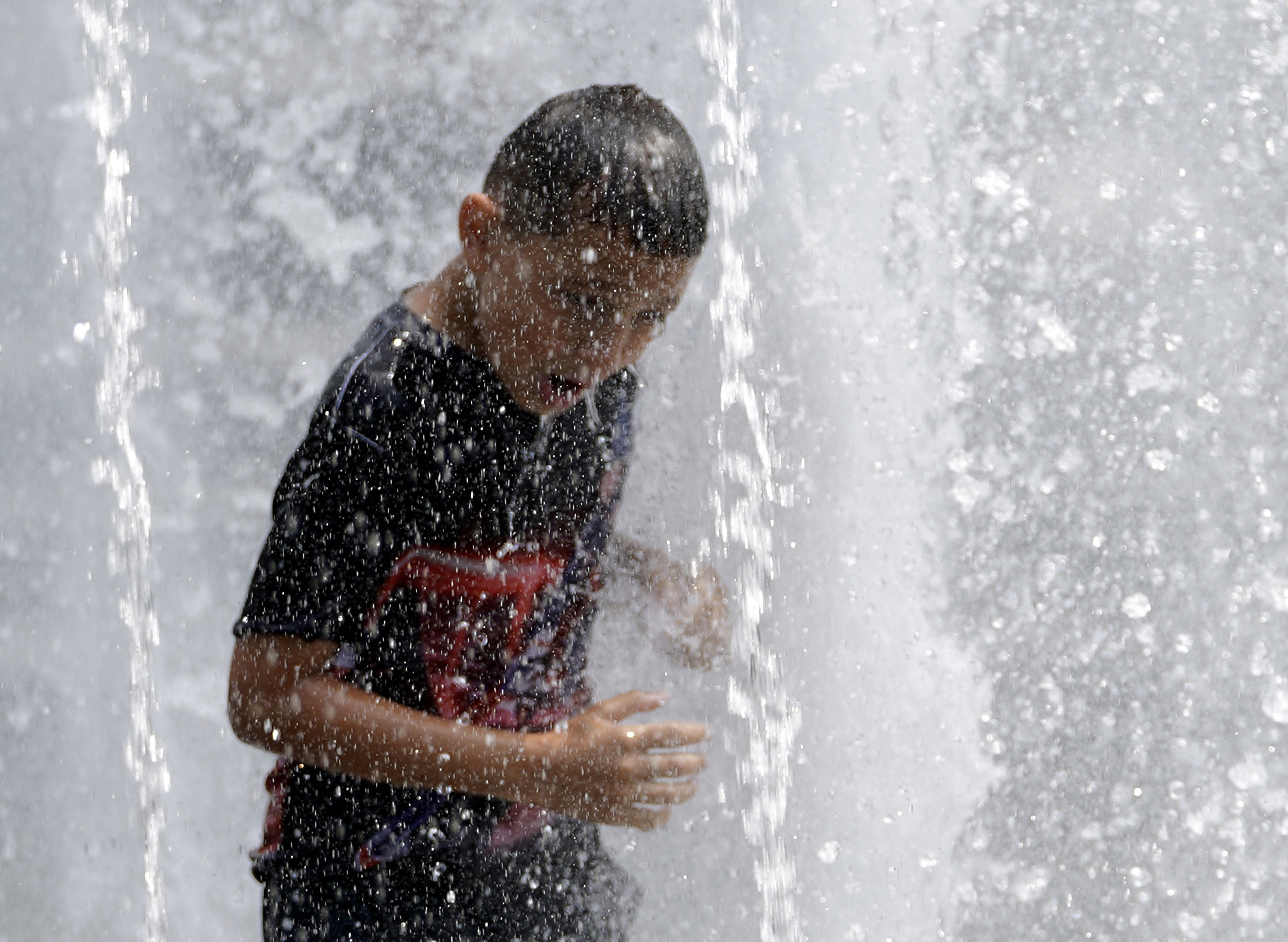 Un niño se refresca en una fuente en Washington Square Park en Nueva York. EE. UU. (Foto Prensa Libre: AFP)