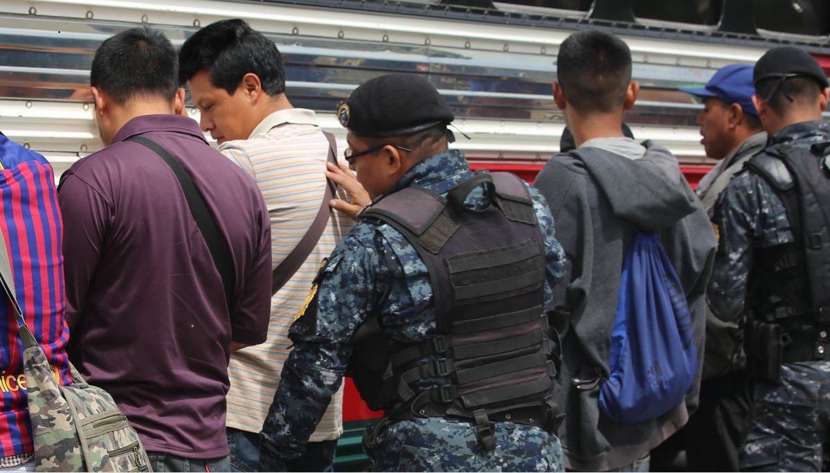 Agentes de la PNC hacen una revisión a pasajeros de un autobús. (Foto Prensa Libre: PNC).