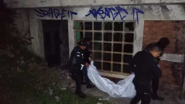Agentes de la Policía Nacional Civil trasladan uno de los cadáveres de las jóvenes a la morgue del Inacif. (Foto Prensa Libre: María José Longo)