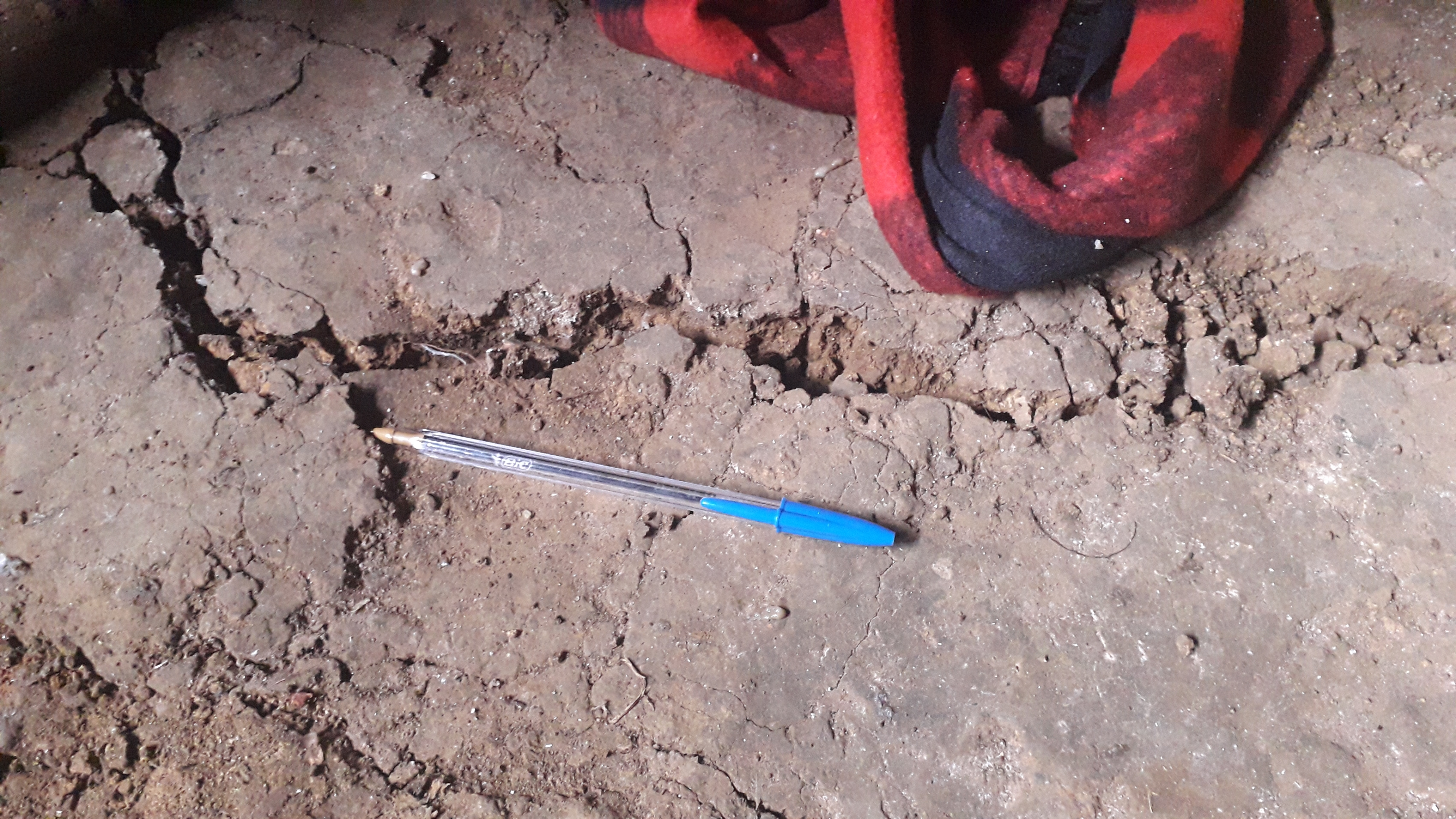 Una pluma se toma como referencia de las grietas registradas en localidades de Quiché. (Foto: Conred)