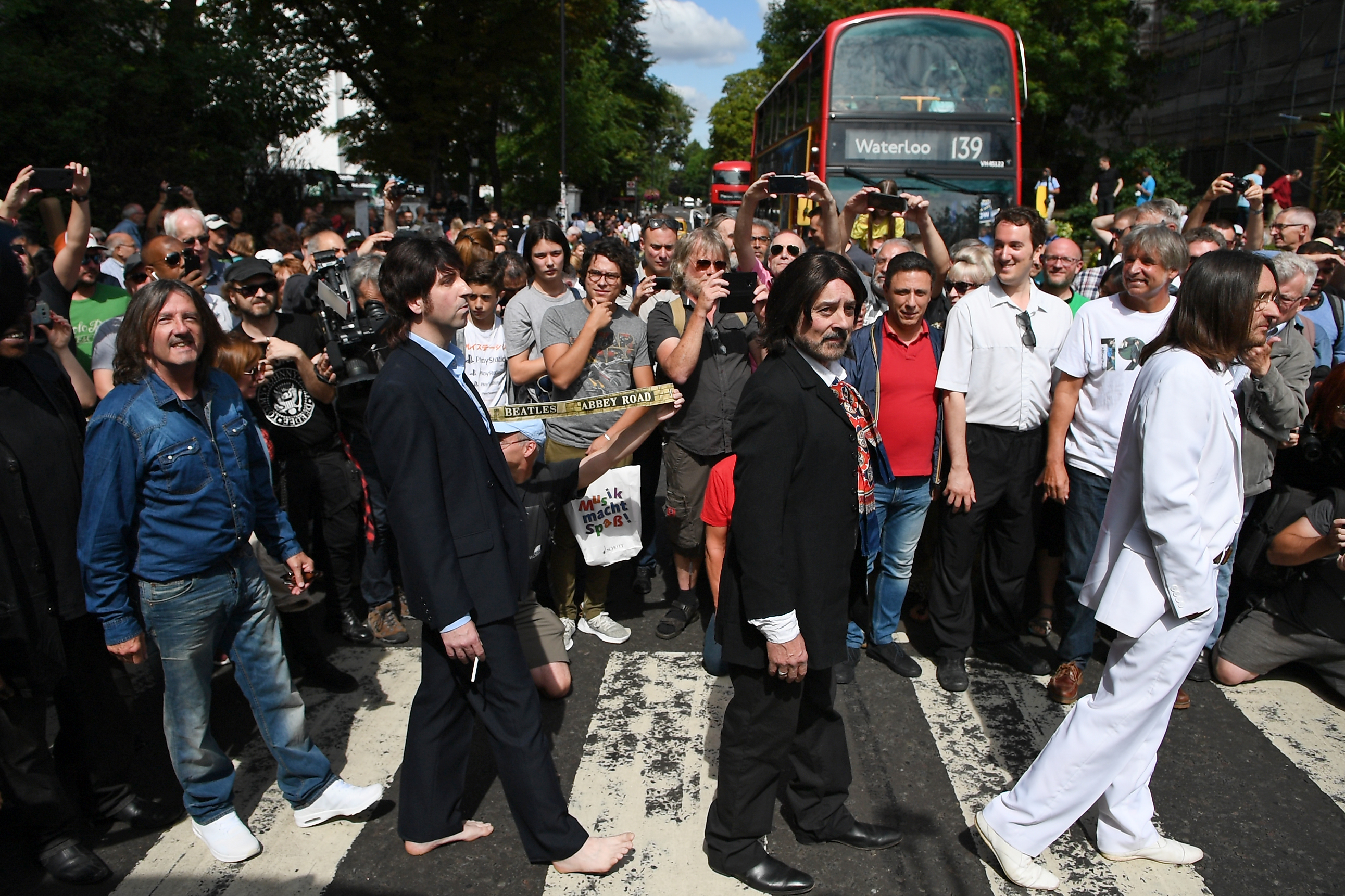 Fans de Los Beatles recordaron la icónica fotografía sobre el paso de cebra. (Foto Prensa Libre: AFP) 