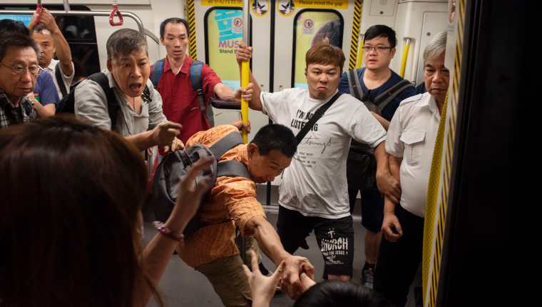 Manifestantes y viajeros se enfrentan en un tren subterráneo del Tren de Tránsito Masivo (MTR) mientras los manifestantes interrumpen los servicios al evitar que las puertas del tren se cierren en la estación Diamond Hill. (Foto Prensa Libre: EFE)