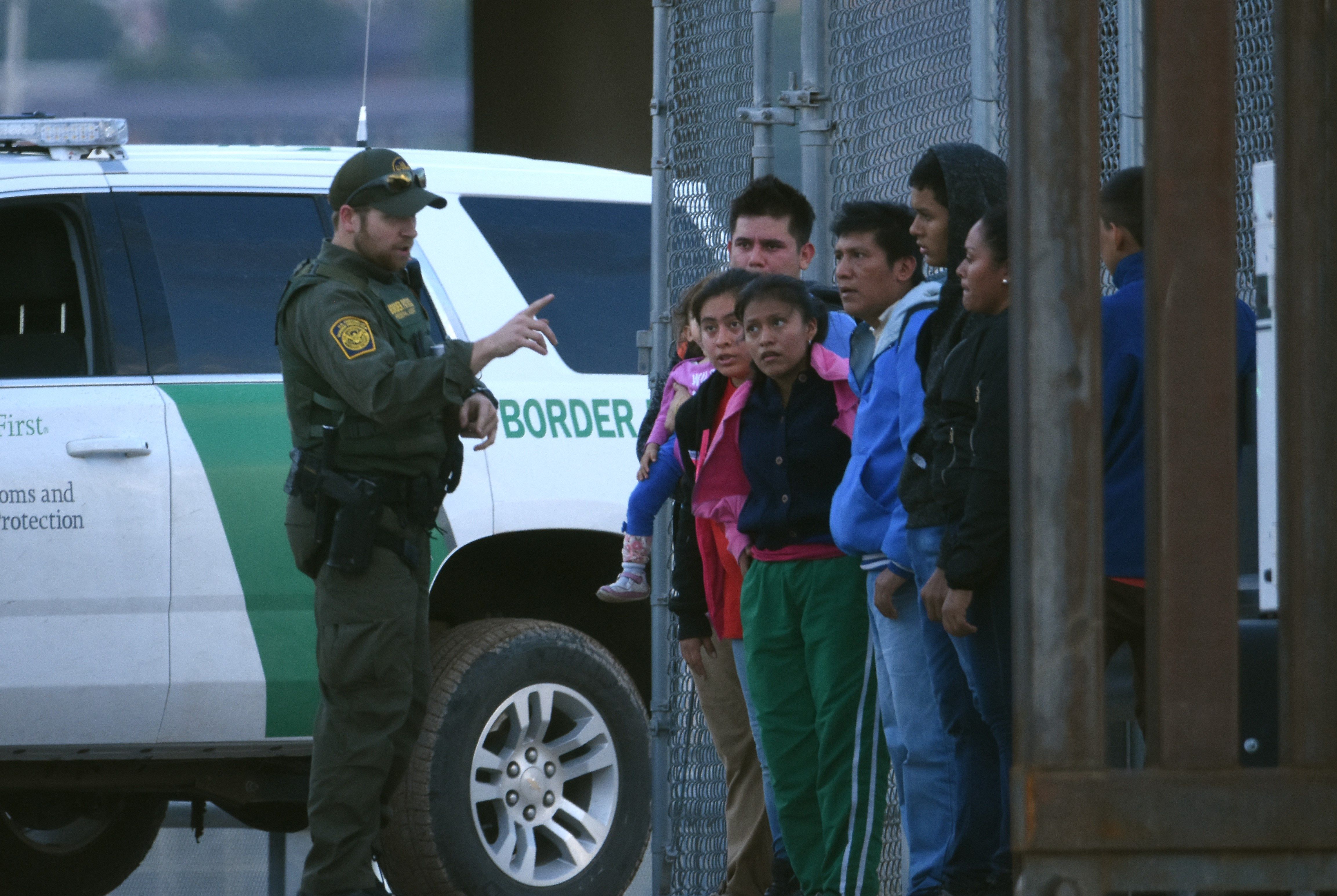 Un agente de la patrulla fronteriza estadounidense habla a un grupo de jóvenes migrantes centroamericanos tras ser detenidos en la orilla del Rio Bravo, en la fronteriza Ciudad Juárez. (Foto Prensa Libre: EFE)