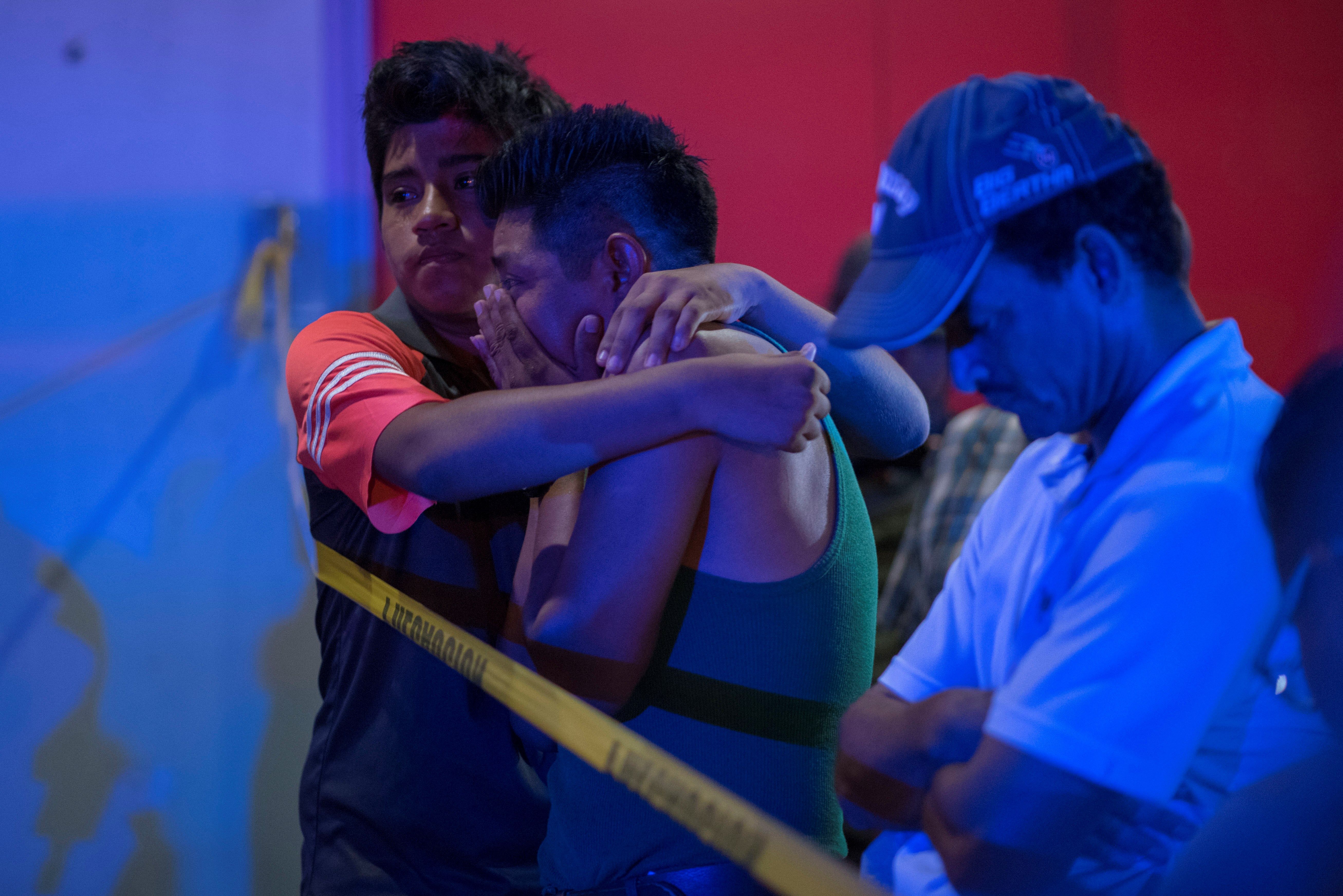 Familiares de las víctimas aguardan al exterior del local donde al menos 23 personas murieron. (Foto Prensa Libre: EFE)