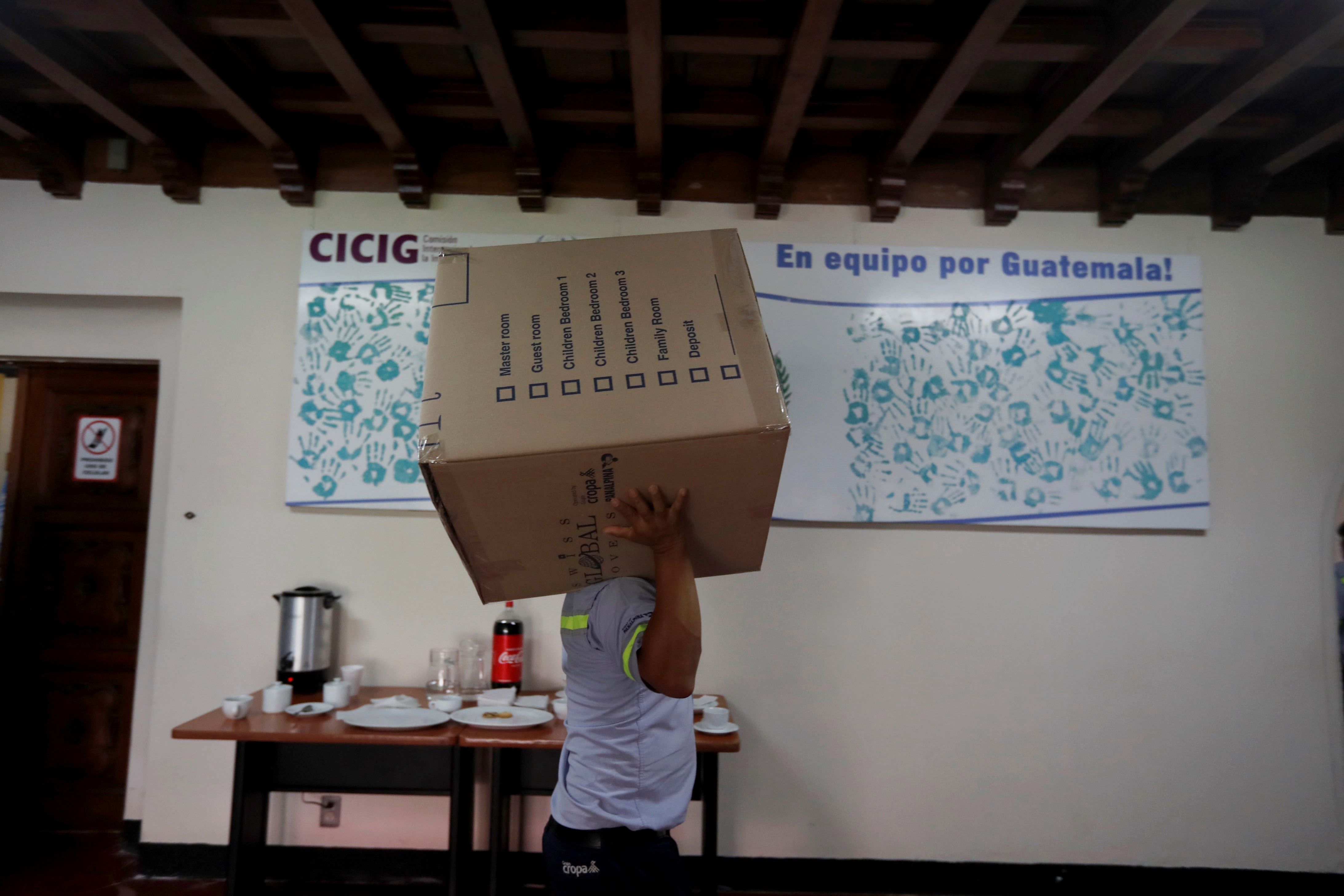 Trabajadores sacan las últimas cajas de la que fue la sede de la Comisión Internacional Contra la Impunidad en Guatemala. (Foto Prensa Libre: EFE) 