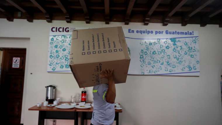 Trabajadores sacan las últimas cajas de la que fue la sede de la Comisión Internacional Contra la Impunidad en Guatemala. (Foto Prensa Libre: EFE) 