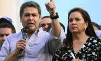 Handout picture released by the Honduran presidency press office showing Honduran President Juan Orlando Hernandez -who was accused of allegedly being linked to drug trafficking- next to his wife Ana Garcia while addressing supporters, in Tegucigalpa on August 6, 2019. - Hundreds of people took to the streets today demanding Hernandez's resignation. (Photo by HO / AFP) / RESTRICTED TO EDITORIAL USE - MANDATORY CREDIT "AFP PHOTO /  HONDURAS PRESIDENCY PRESS OFFICE" - NO MARKETING - NO ADVERTISING CAMPAIGNS - DISTRIBUTED AS A SERVICE TO CLIENTS