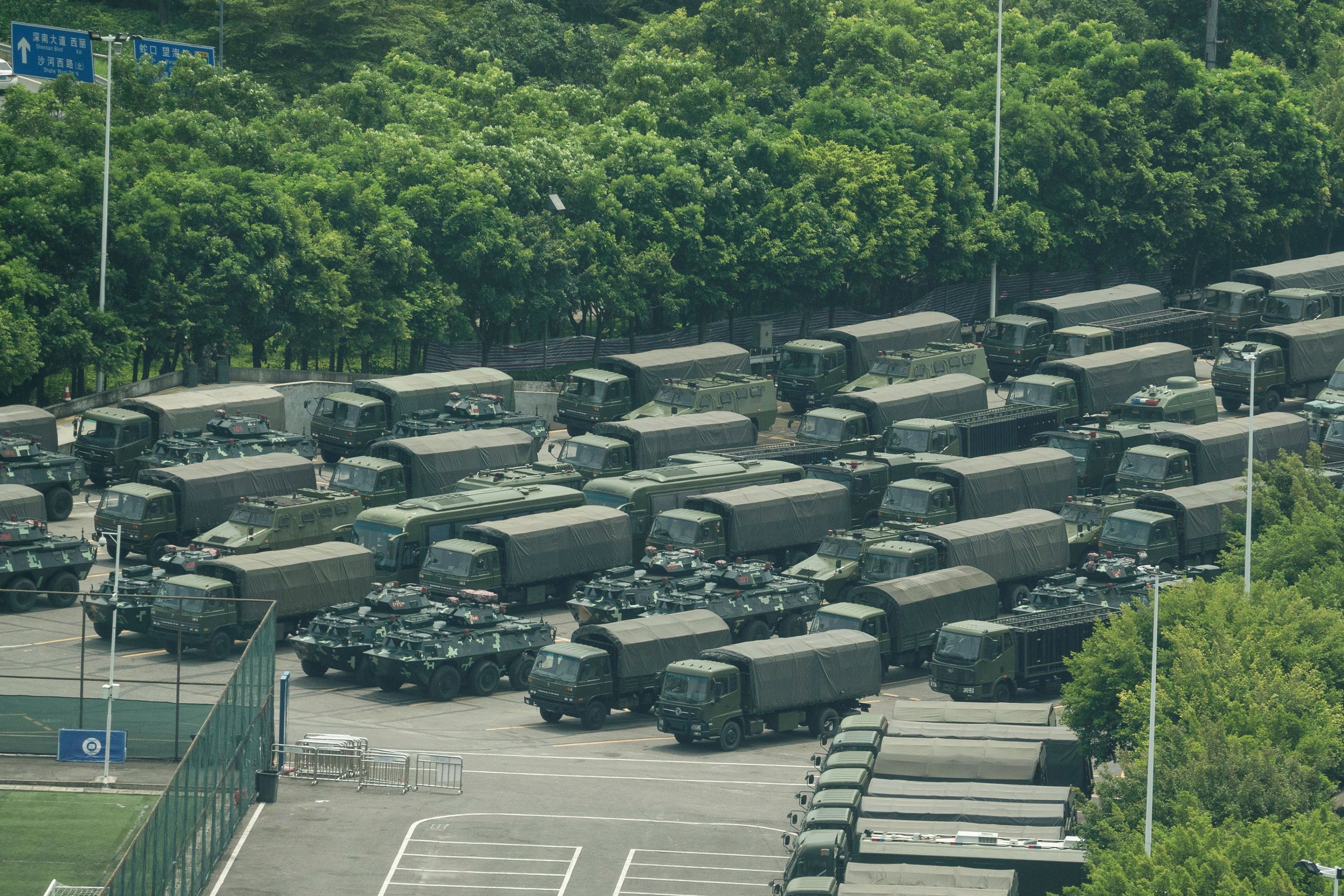Camiones y vehículos blindados se ven fuera del estadio de la Bahía de Shenzhen en Shenzhen, en la frontera con Hong Kong en la provincia meridional china de Guangdong. (Foto Prensa Libre: AFP). 